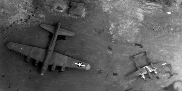Monochrome image of a plane from above and landscape below. 